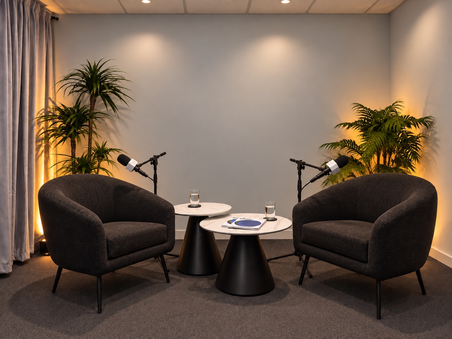 The casual setup ready to record, with two lounge armchairs, marble tables and microphones under warm ambient lighting