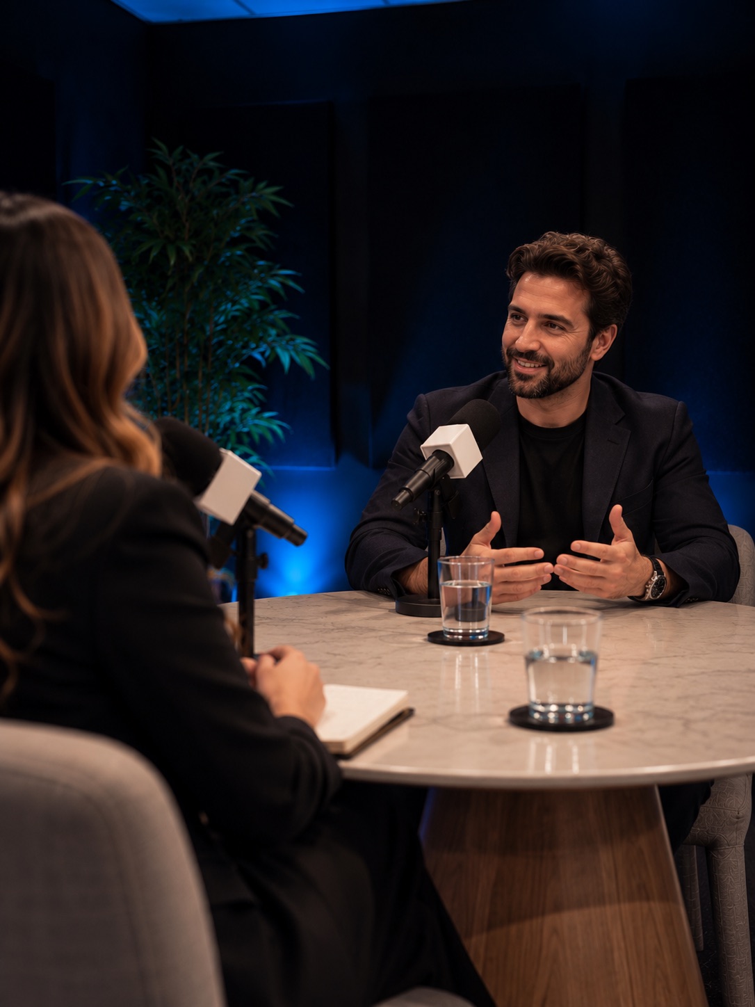 Guest speaking into a microphone across the table in the executive podcast setup